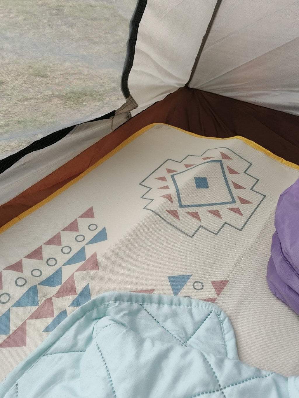 Aztec printed picnic mat laid out inside a tent