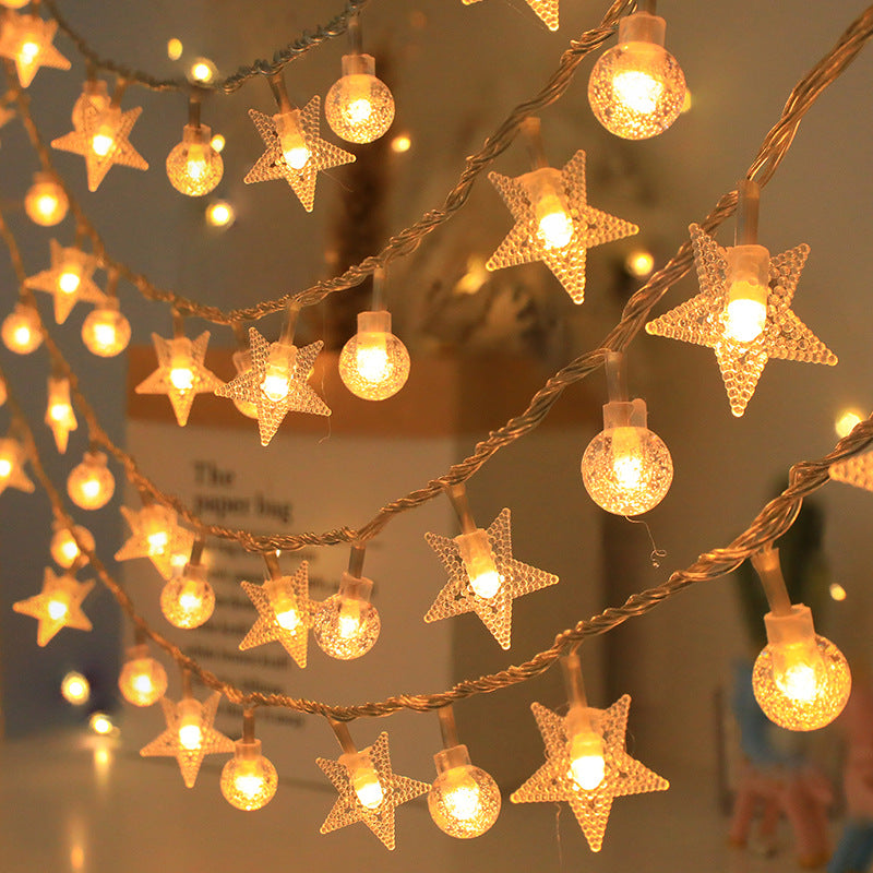 Close-up of warm white star and crystal ball solar string lights glowing