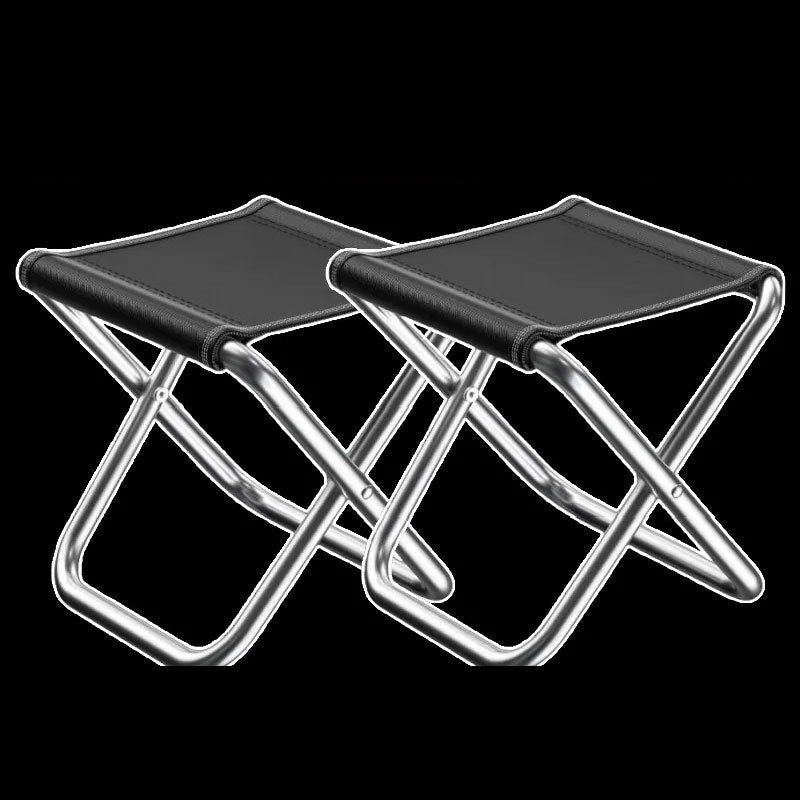 Pair of aluminum folding camp stools with black fabric seats against a black background